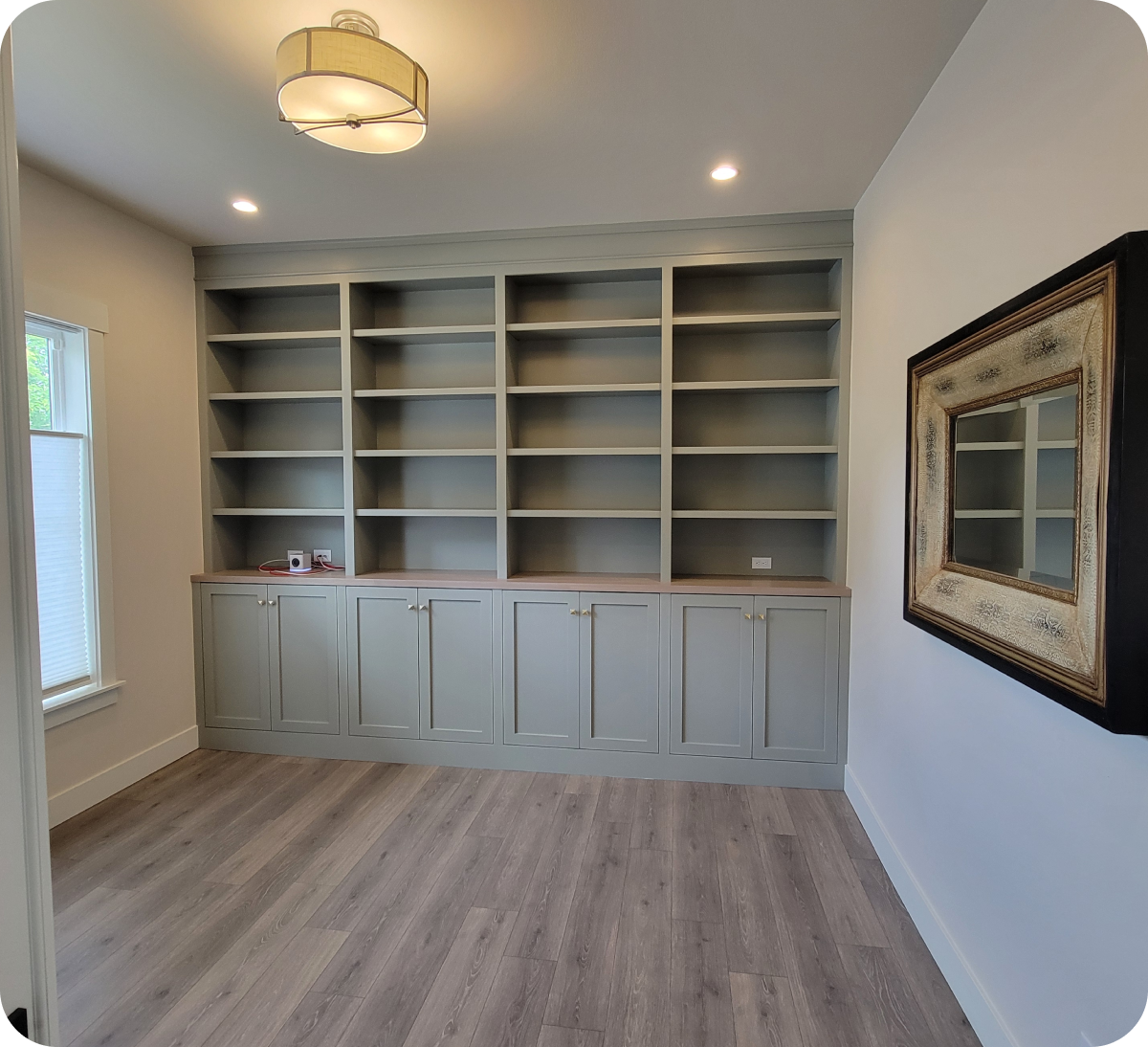 Empty room with built-in shelves and mirror.